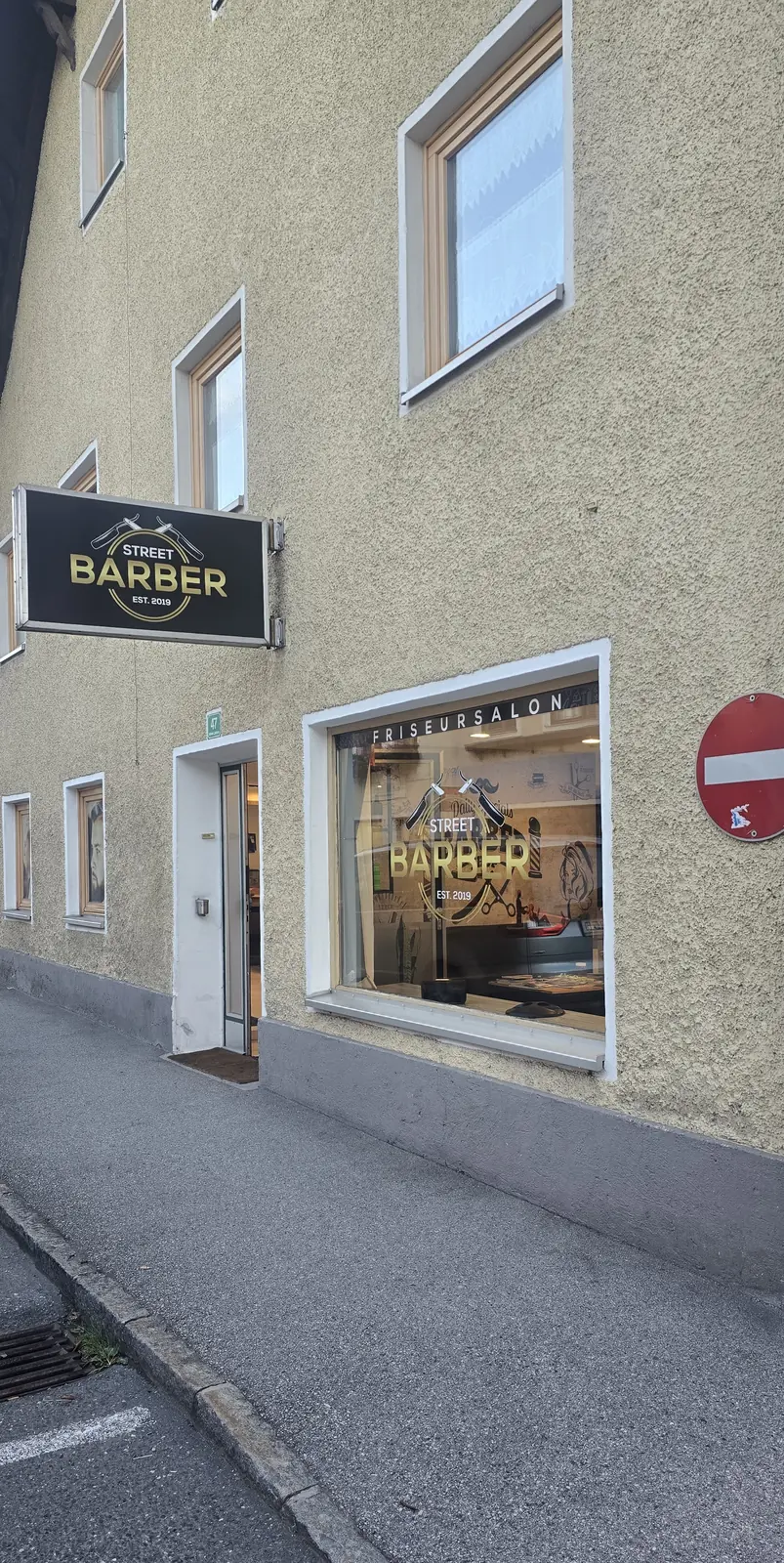 Hausfassade von Street Barber mit Ladenschild „Street Barber Est. 2019“ und Schaufenster „Friseursalon“